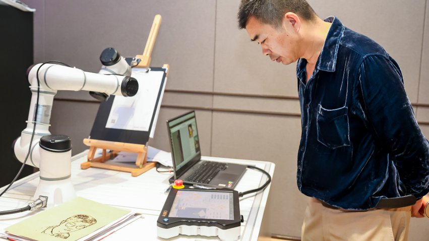 嘉賓體驗遨博AI繪畫機器人。主辦方供圖